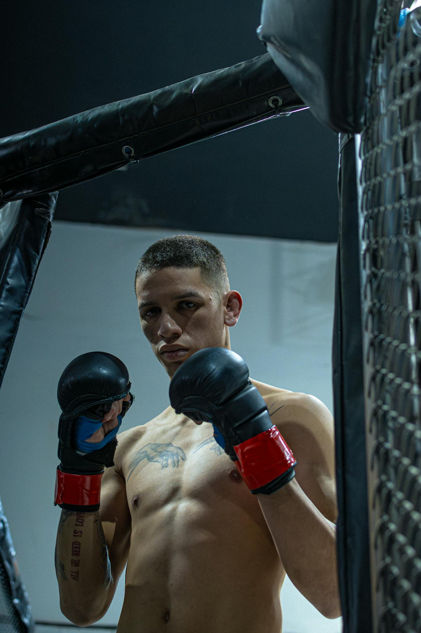 A serious MMA fighter standing in a cage arena, ready for competition.